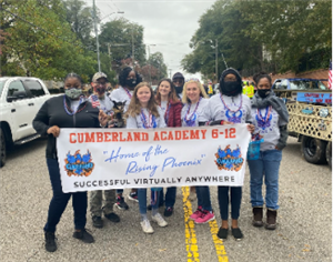 Group of students and staff holding Cumberland Academy 6-12 banner for Veterans Day Parade November 2021